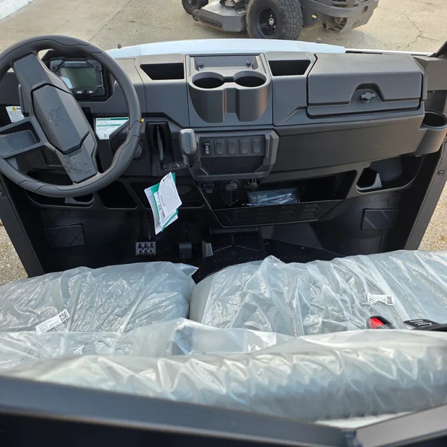 Dash and steering wheel inside a Bobcat UV34 utility vehicle, seats still in factory wrap, at Dykes Motors, Collins, Mississippi