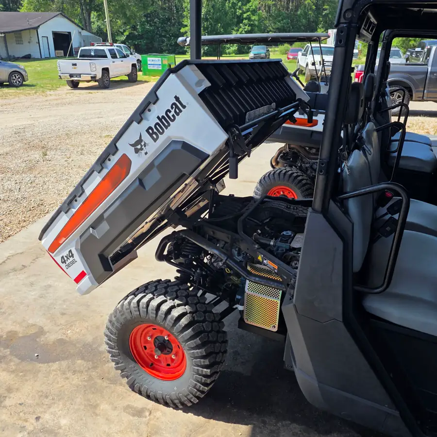 Bobcat UV34 with its cargo box tipped all the way up, showing the dump bed raised