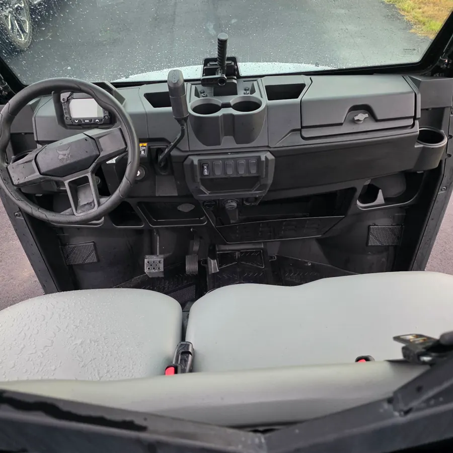 Inside a Bobcat UV34 — steering wheel, digital gauge cluster, center controls and the bench seat